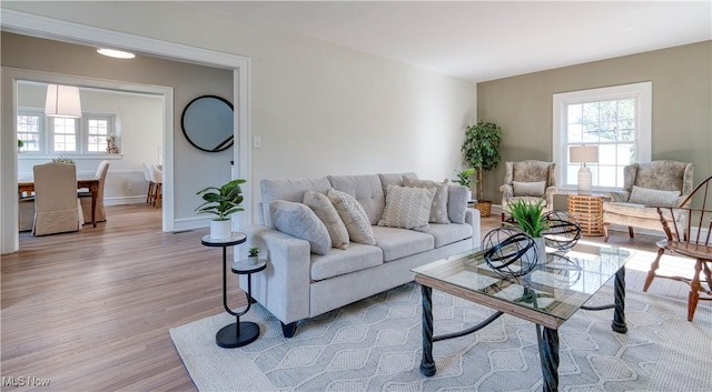 living room featuring a wealth of natural light, baseboards, and light wood-style floors