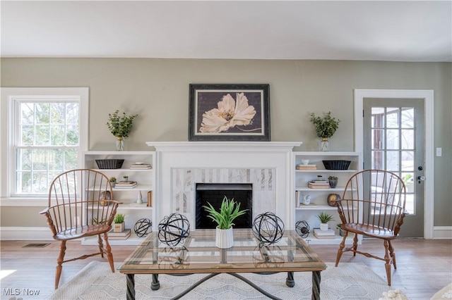 living room featuring wood finished floors, a fireplace, and baseboards