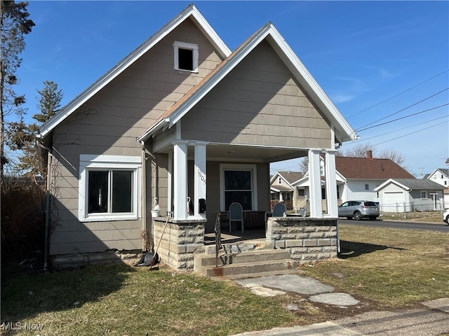 bungalow featuring a porch and a front lawn