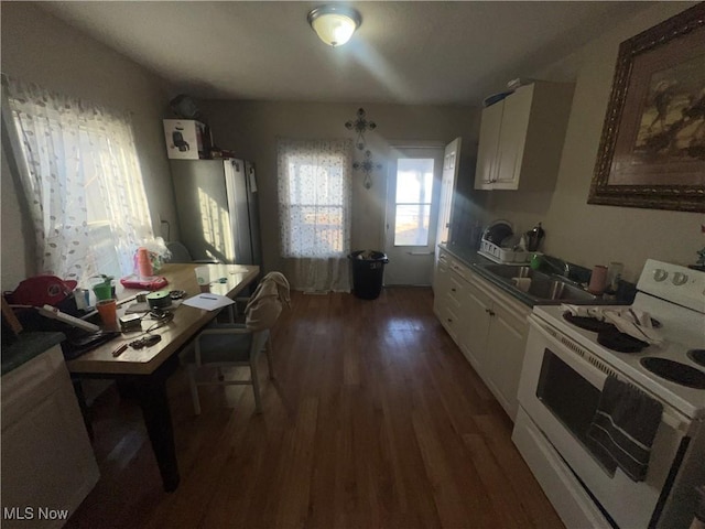 kitchen with a sink, white cabinets, dark wood finished floors, and white range with electric stovetop