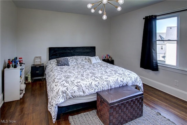 bedroom featuring baseboards, a notable chandelier, and wood finished floors