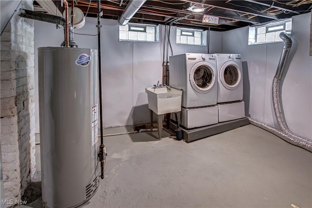 below grade area featuring gas water heater, washing machine and dryer, and a sink