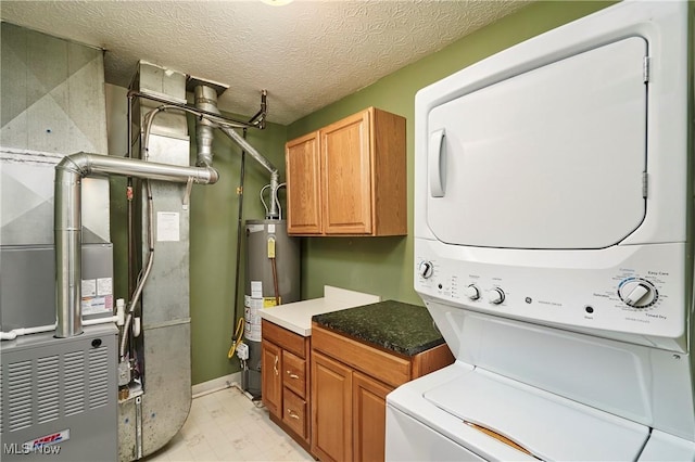 laundry area featuring gas water heater, light floors, stacked washer and clothes dryer, cabinet space, and a textured ceiling