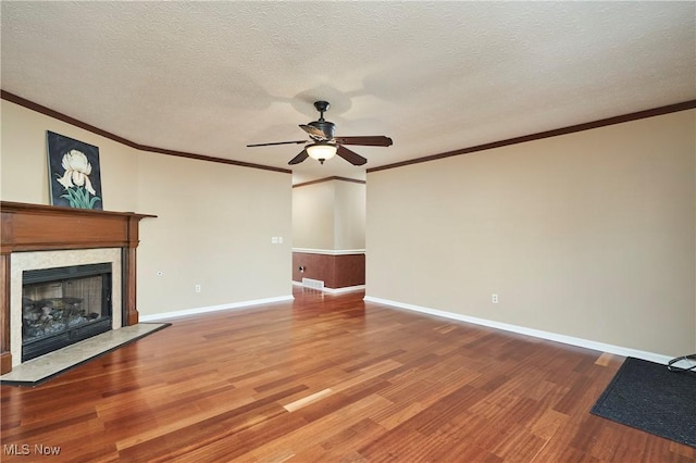 unfurnished living room featuring a fireplace, wood finished floors, a ceiling fan, and a textured ceiling