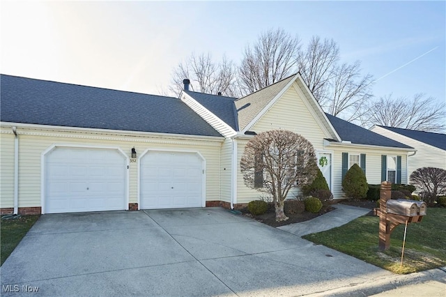 ranch-style house featuring concrete driveway, a garage, and roof with shingles