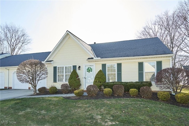 ranch-style home featuring a shingled roof, concrete driveway, a garage, and a front yard