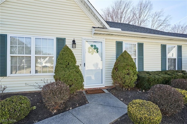 property entrance featuring a shingled roof