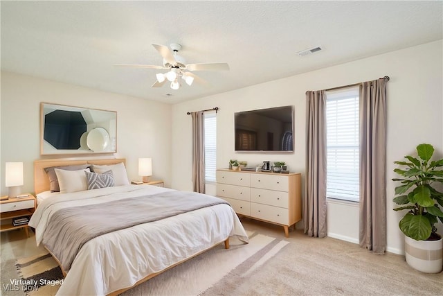 bedroom with light carpet, baseboards, visible vents, and ceiling fan