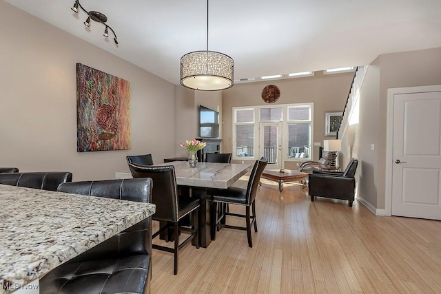 dining room featuring light wood-type flooring and baseboards