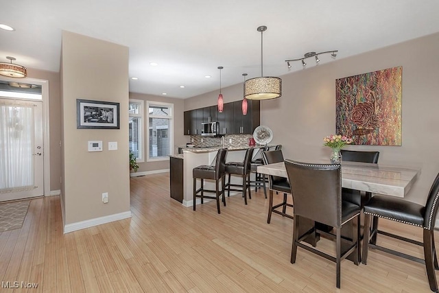 dining room with recessed lighting, baseboards, and light wood finished floors