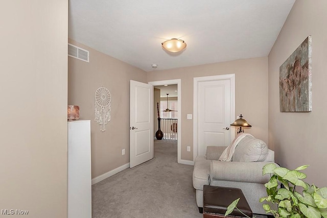 sitting room featuring light carpet, visible vents, and baseboards