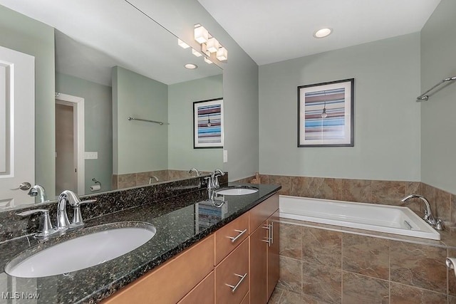 full bathroom with double vanity, a bath, and a sink