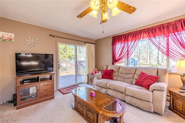 carpeted living area with ceiling fan