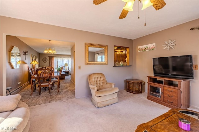 carpeted living room featuring ceiling fan with notable chandelier