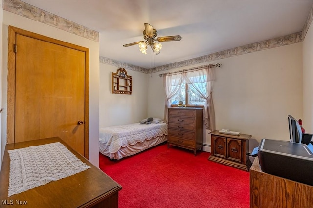 bedroom with a ceiling fan, dark colored carpet, and a baseboard radiator