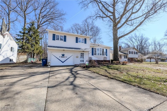 tri-level home with driveway, a front yard, and a garage