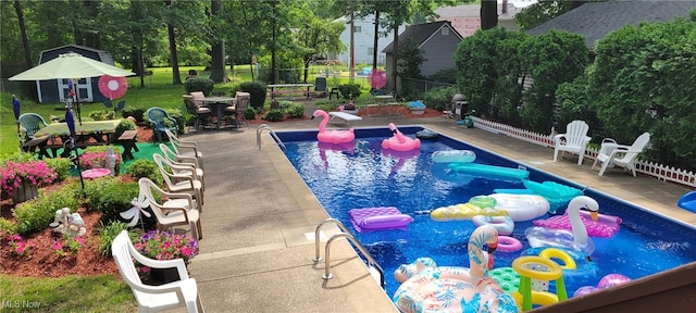 view of swimming pool with a fenced in pool, a diving board, a patio, and fence