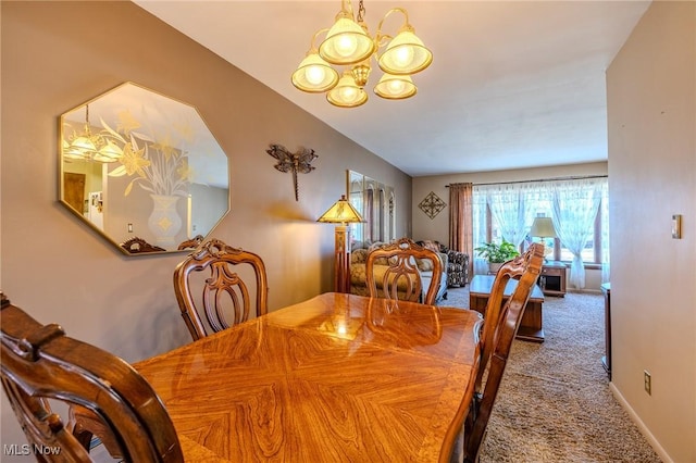 carpeted dining room with a notable chandelier and baseboards