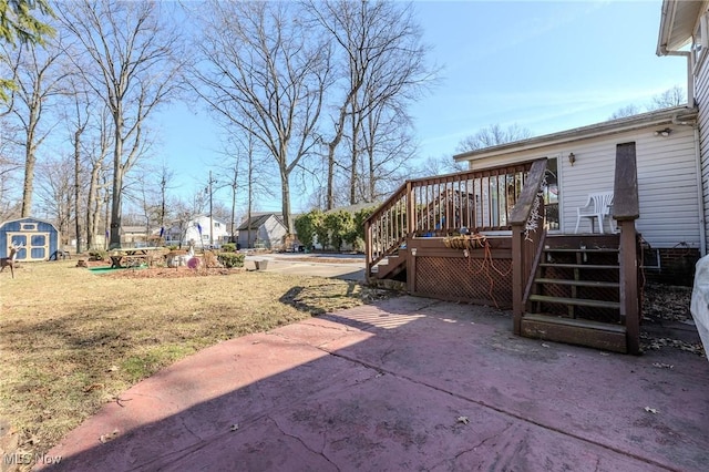 view of yard featuring a storage unit, a deck, an outdoor structure, and stairs