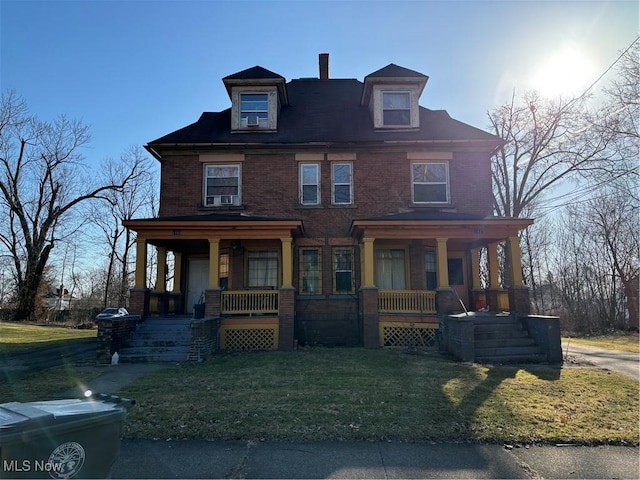 view of front of house featuring a front yard, cooling unit, brick siding, and covered porch