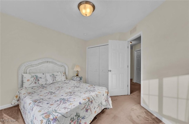 carpeted bedroom featuring baseboards, visible vents, and a closet