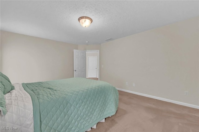 bedroom featuring visible vents, baseboards, carpet floors, and a textured ceiling