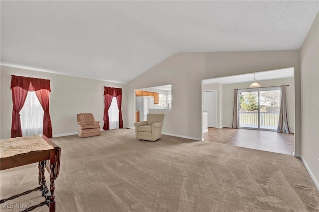 living area featuring baseboards, carpet flooring, and vaulted ceiling