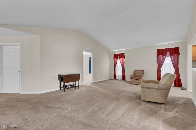 sitting room featuring baseboards, lofted ceiling, and carpet