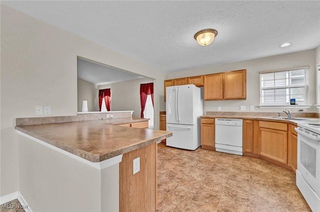 kitchen with a textured ceiling, white appliances, a peninsula, and a sink