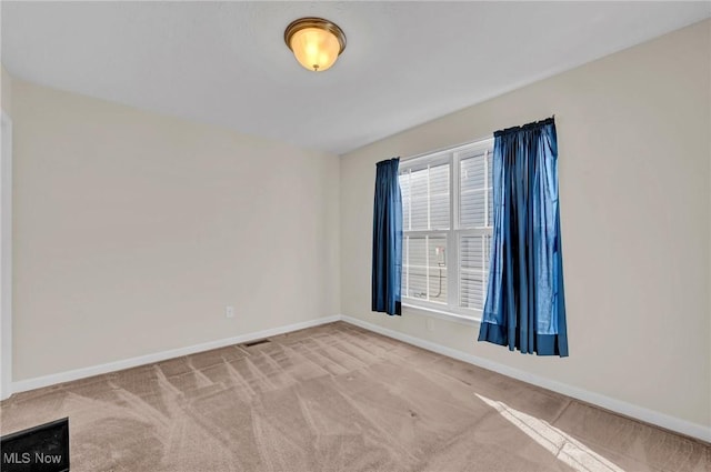 empty room with visible vents, baseboards, and carpet