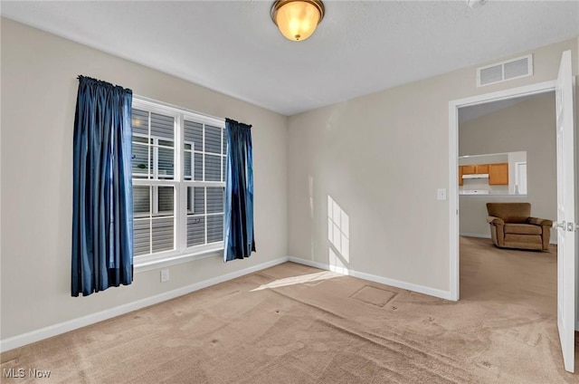 spare room featuring visible vents, baseboards, and carpet