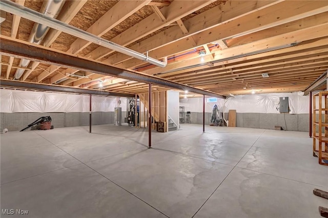 basement featuring electric panel and water heater