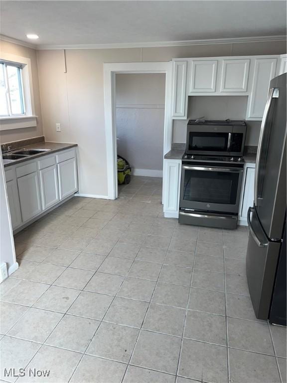 kitchen with light tile patterned floors, ornamental molding, stainless steel appliances, and a sink