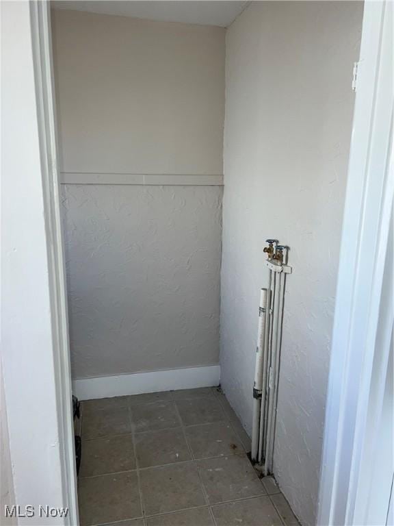 laundry area featuring baseboards, laundry area, and tile patterned flooring