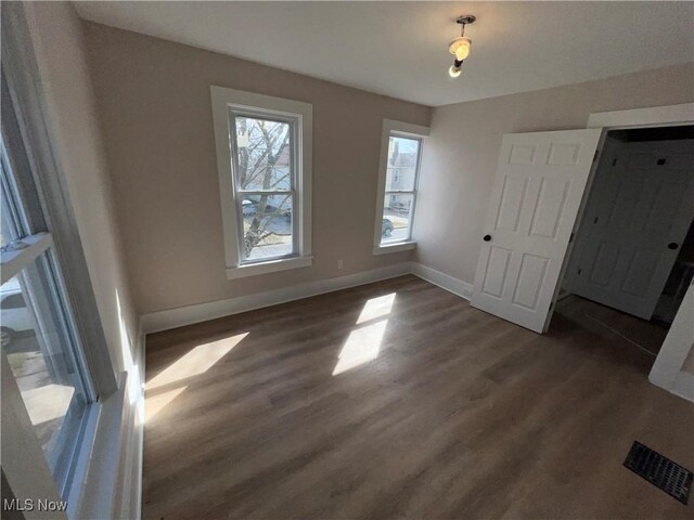 interior space featuring wood finished floors, visible vents, and baseboards