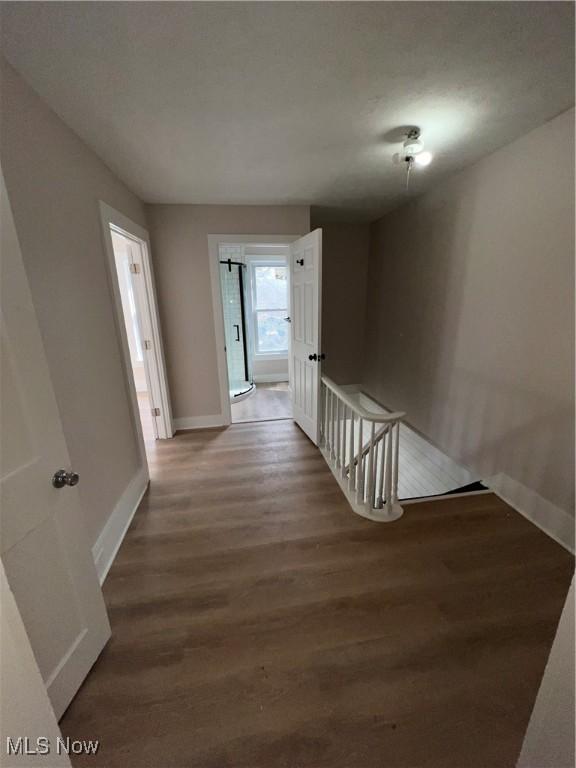 hallway with baseboards and wood finished floors