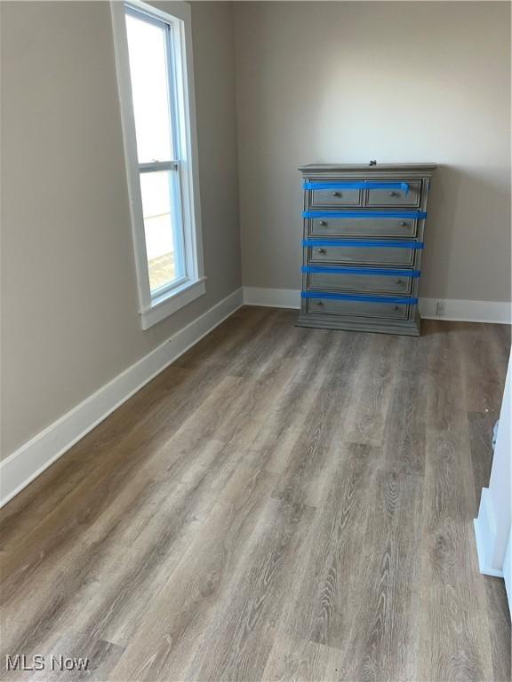 empty room with baseboards and wood finished floors