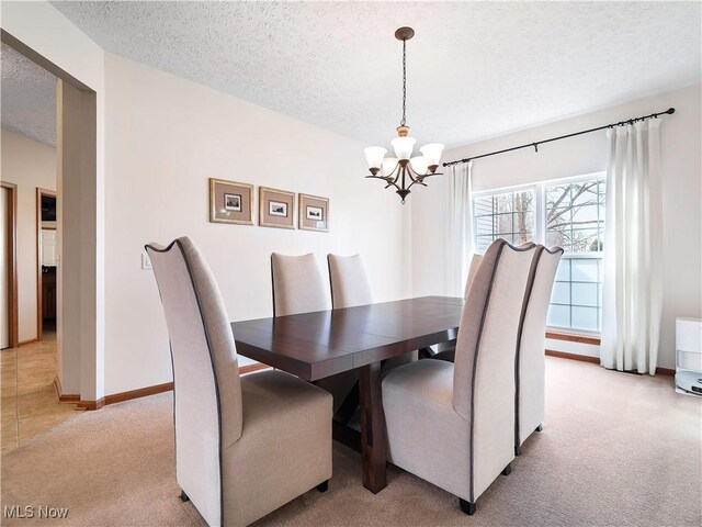 dining area with baseboards, light carpet, a textured ceiling, and a chandelier