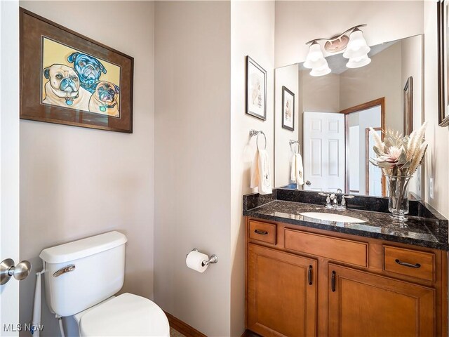 half bathroom with toilet and vanity