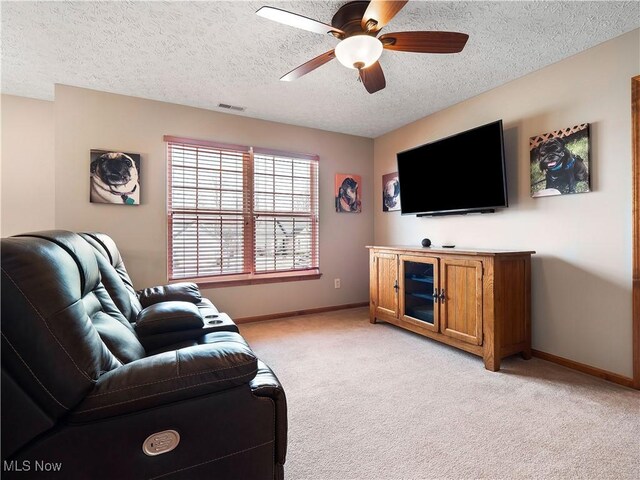 living area with ceiling fan, baseboards, visible vents, and light carpet