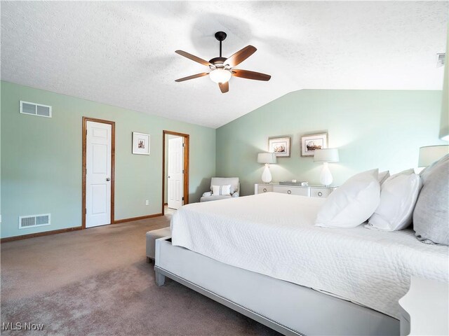 bedroom with visible vents, lofted ceiling, and a textured ceiling