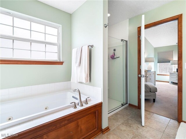 ensuite bathroom featuring a jetted tub, connected bathroom, a stall shower, and a textured ceiling