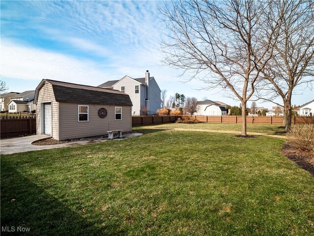 view of yard with an outbuilding, a residential view, and fence