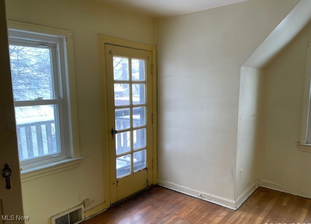 interior space with wood finished floors, visible vents, and baseboards