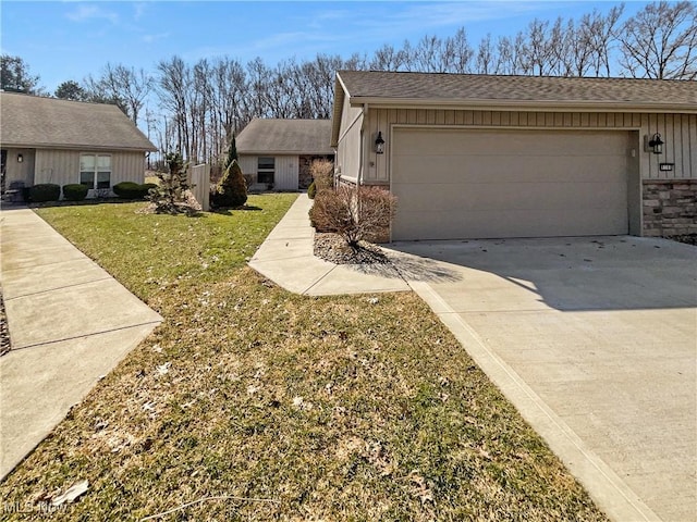 view of front of property featuring a front yard, roof with shingles, an attached garage, concrete driveway, and board and batten siding