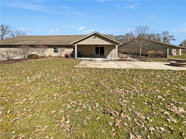 rear view of house with a patio, fence, a lawn, and an outdoor fire pit