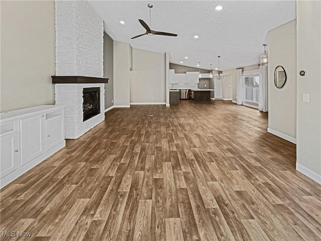 unfurnished living room with recessed lighting, ceiling fan, dark wood finished floors, and vaulted ceiling