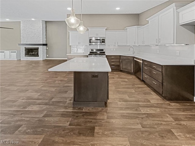 kitchen featuring a sink, stainless steel appliances, backsplash, and white cabinetry