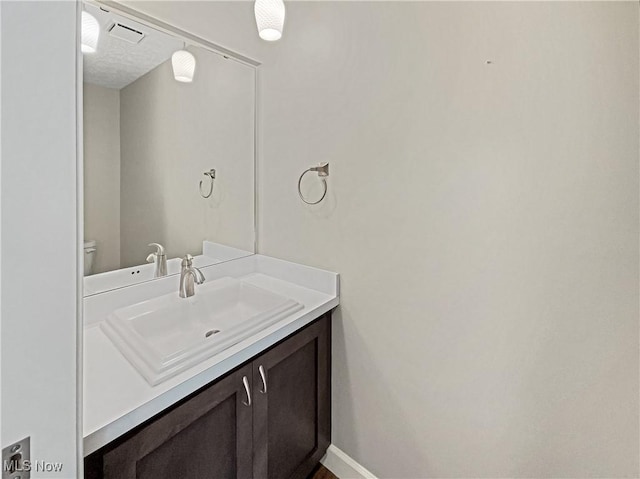 bathroom with visible vents, baseboards, and vanity