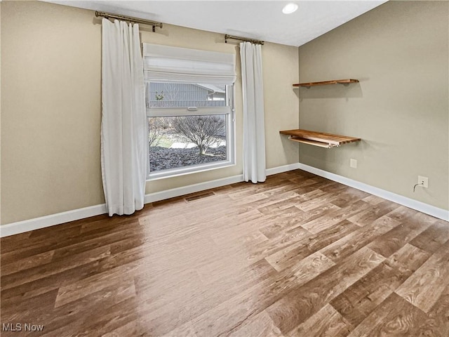 spare room with visible vents, recessed lighting, wood finished floors, and baseboards